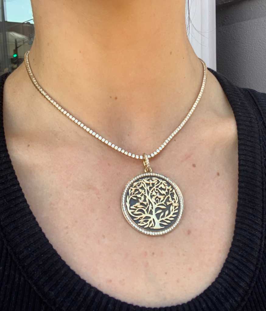 Syna Tree of Life pendant hanging from Leonardo Jewelers tennis necklace